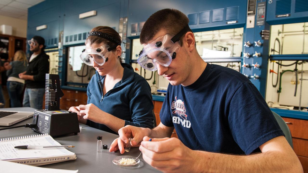 化学 students in lab wearing protective goggles.